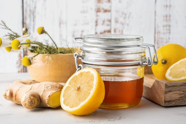 Alternative medicine, natural home remedy for cold and flu. Glass jar with honey, ginger, lemon and chamomille