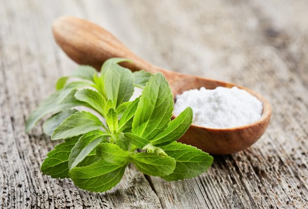 Stevia plant with powder on wooden board