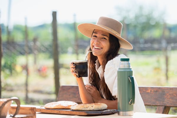 beautiful latin woman with hat drinking yerba mate